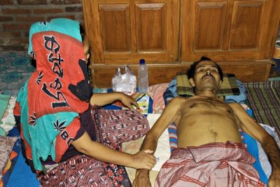 Karim terbaring ditemani istrinya Siti Suwarni. Foto: Bin