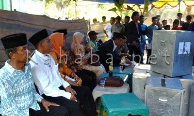 Calon Kepala Desa Punti tengah duduk bersanding dengan istri saat proses perhitungan suara. Foto: Noval